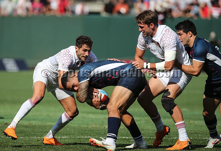 2018RugbySevensSat-33.JPG - United States player Martin Losefo protects the ball against England in the men's championship quarter finals of the 2018 Rugby World Cup Sevens, Saturday, July 21, 2018, at AT&T Park, San Francisco. England defeated USA 24-19 in sudden death play. (Spencer Allen/IOS via AP)